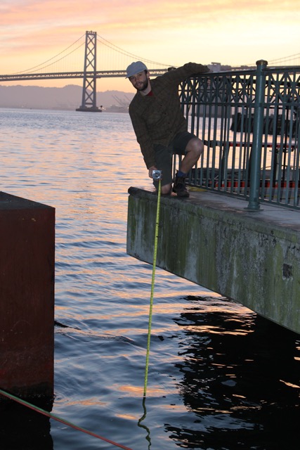 Kevin Stark measuring high tide at the Ferry Building in San Francisco.