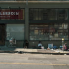 People congregate on the sidewalk to chat and sell found goods outside the Tenderloin Museum on Leavenworth and Eddy streets in late June.