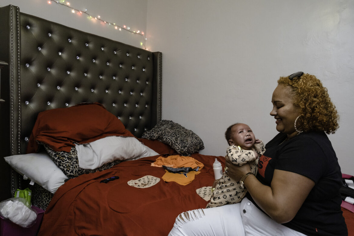 Tolbert comforts Supreme inside her bedroom. Tolbert has changed him into clean clothes, but the baby wants a nap. In her new home, Tolbert is able to maintain everyday comforts, but her happiness comes from “always being mentally in a comfortable place,” Tolbert said. “Like you should be in any situation, be comfortable and happy.” Tolbert does not want much but a safe space to raise her child. “Comfortable is knowing I have the baby,” she said. “Teach him and just learn how to be a parent.”