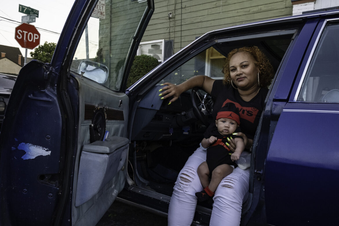 Tantay Tolbert poses for a portrait with her son Supreme inside her 1977 Chevrolet Impala in front of her apartment in Richmond. She is hoping to get $10,000 when she sells this classic vehicle. Since the pandemic started, Tolbert and her partner have increased their car sales. “People are buying equity, and they can get to where they need to go,” she said. Tolbert says she has used some of her unemployment benefits to buy cars at auctions. She and her partner fix up the cars and sell them to people — some of whom are using their own unemployment benefits to pay for the vehicles. “We’ve been doing it since I was 21. I’m 38 now. We can do this with our eyes closed,” Tolbert said confidently. “This has been the whole solid foundation.”