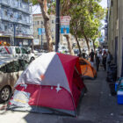 Tents line Golden Gate Avenue while nonprofit and city workers discuss hotel placements with unhoused residents in July 2020.