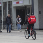 In this photo, a DoorDash delivery person rides a bicycle to make a deliver. Albertsons, Safeway’s parent company, plans to cut hundreds of grocery delivery positions in California and replace them with gig workers from DoorDash.