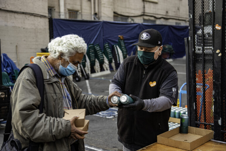 Glide employee James Sampaga hands out water cans donated by Aquaman actor Jason Momoa.