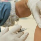 A healthcare worker steadies the needle in preparation for injecting the vaccine into a patient's shoulder. San Francisco plans to launch three high-volume sites to manage the rollout of two COVID-19 vaccines, with the goal of reaching 10,000 people a day, Mayor London Breed announced Friday.