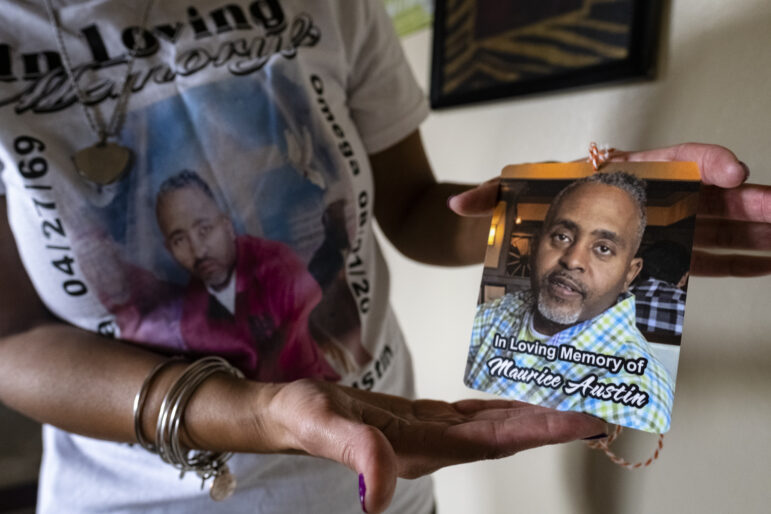 Keeshemah Johnson displays a photo of her partner, Maurice Austin, who died from COVID-19 in August.