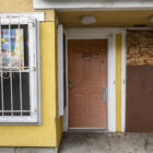 Two front doors to apartments at Plaza East, the one on the right boarded up.