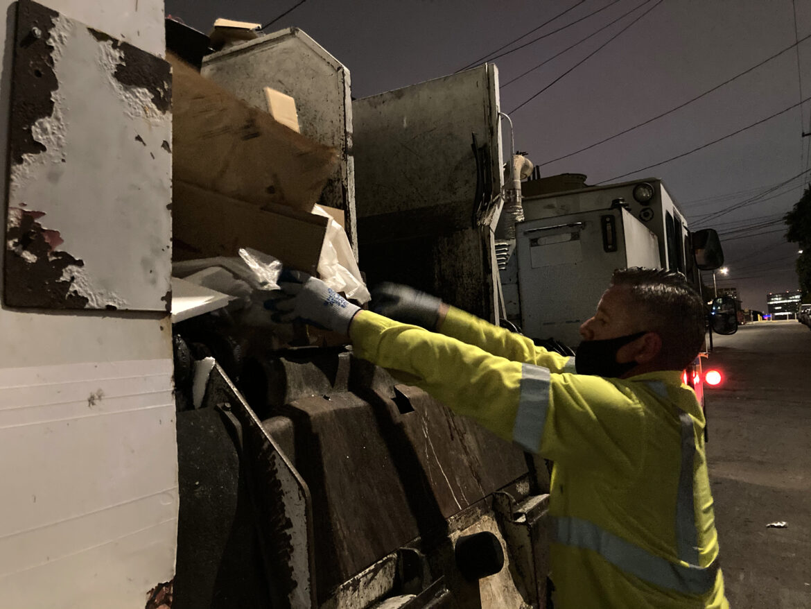 Recycling driver Gareth Willey ensures that cardboard is properly loaded into his truck.