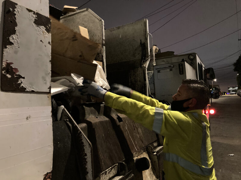 Recycling driver Gareth Willey ensures that cardboard is properly loaded into his truck.