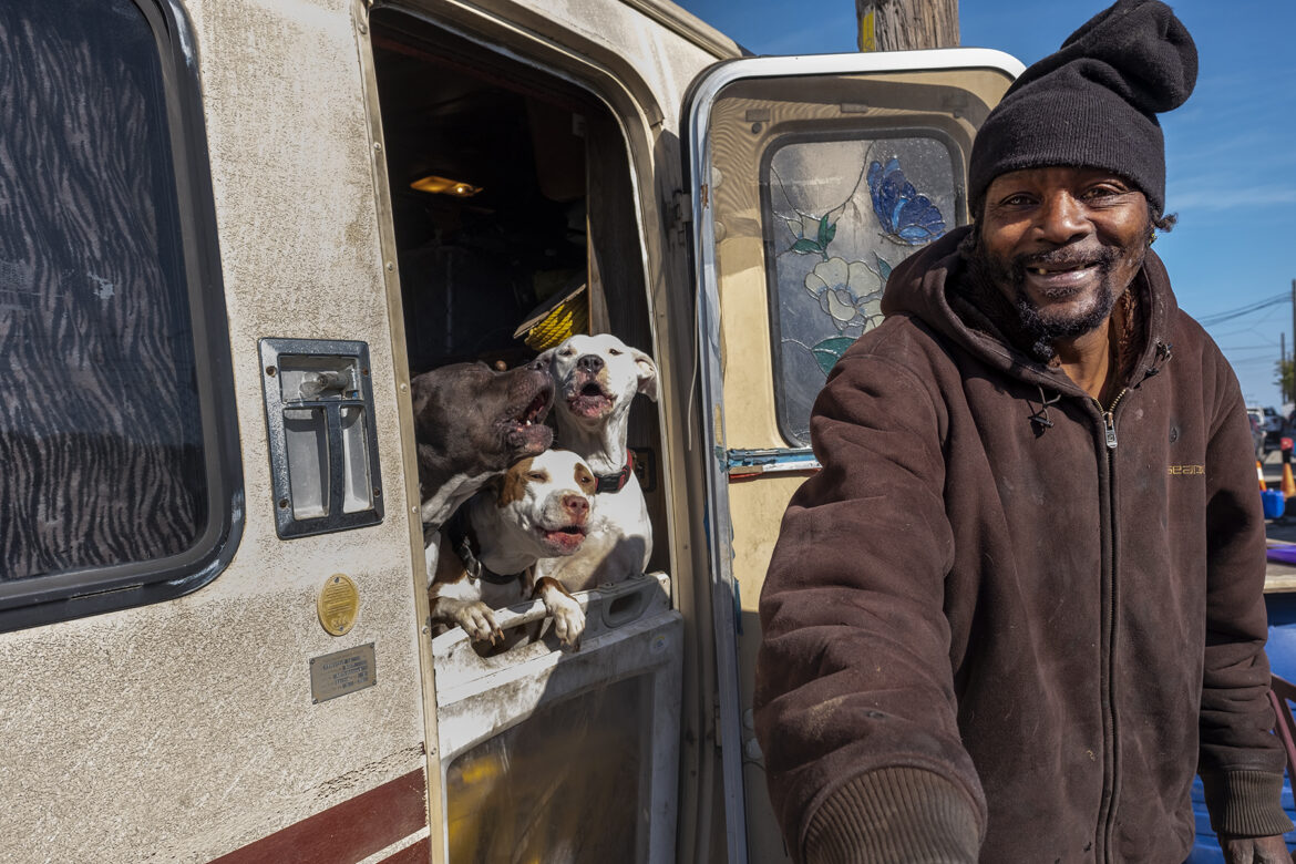 Edward Armstrong smiles after petting his Pitbull dogs, which live in his recreational vehicle on Carroll Avenue in the Bayview neighborhood.