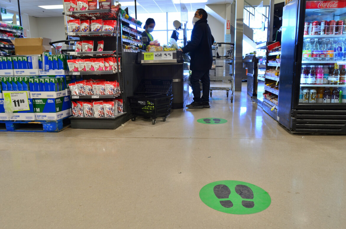 Markings on a store floor indicate where customers should stand to maintain social distance.