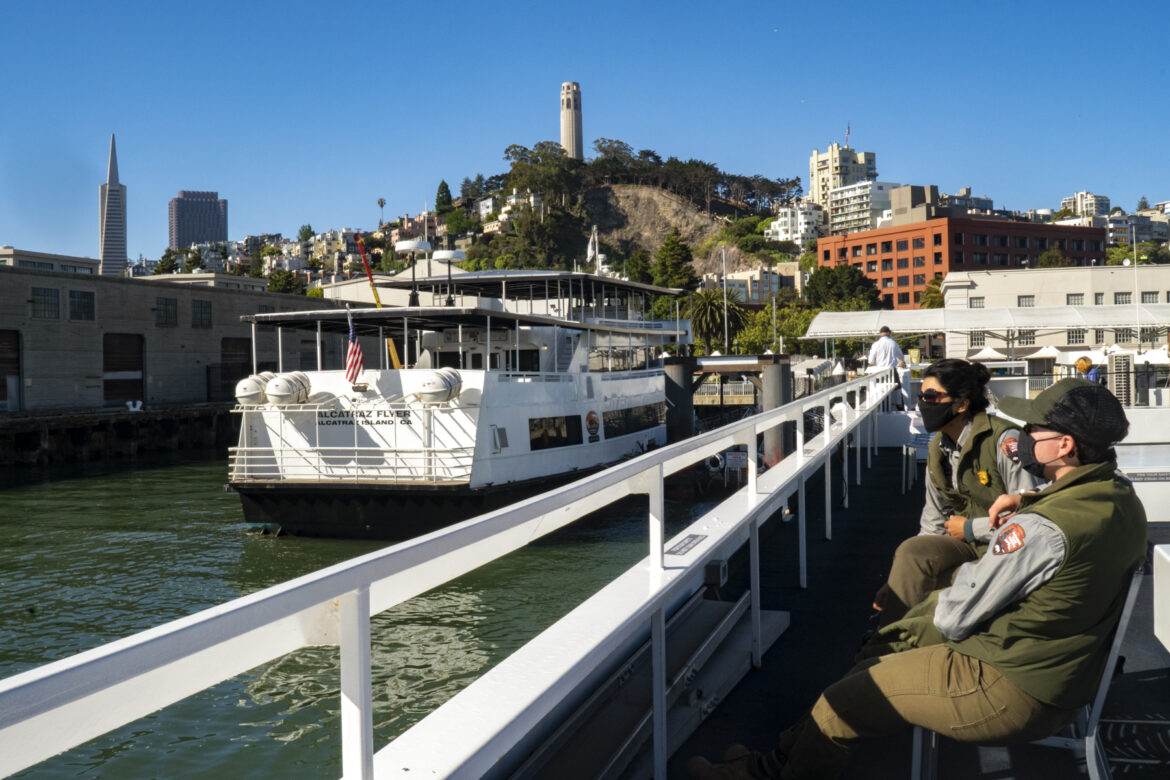 Two National Park rangers wait on the dock before boarding a ferry to work on Alcatraz.