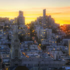 A view of San Francisco's Russian Hill neighborhood, set against a yellow sunset.