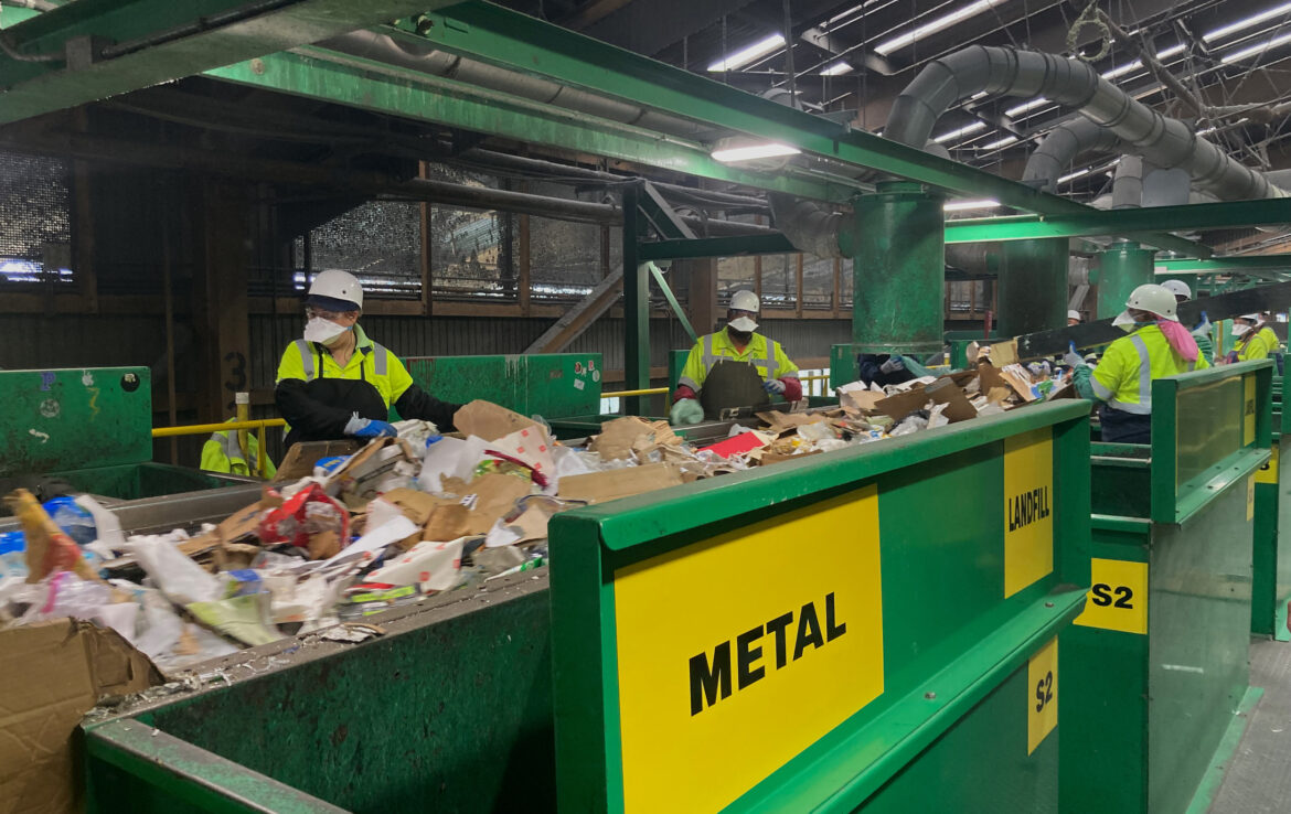 Workers at the initial sort deck inside Recology’s sorting facility at Pier 96 in San Francisco pluck items that cannot be recycled or pose a threat to equipment from a conveyor belt.