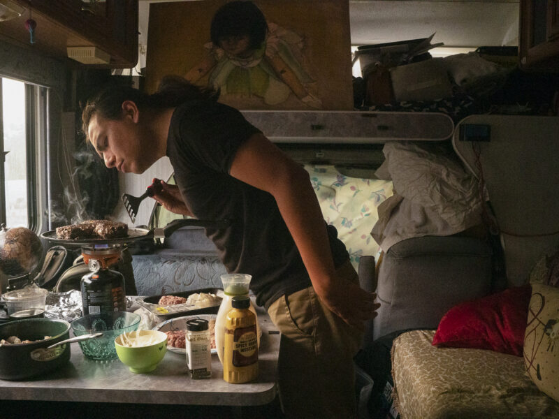 Christian Torres cooks food in the van where he lives in Berkeley.