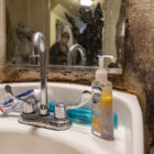 The wall behind a bathroom sink is marred by black mold.