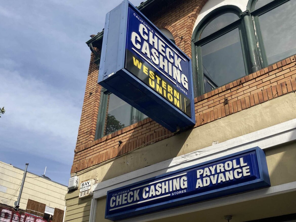 A "check cashing" sign hangs above a storefront. While San Franciscans who owe COVID-19-related rent debt are eligible for relief from the government, those who borrowed from friends, family, and other sources are stuck with that debt.