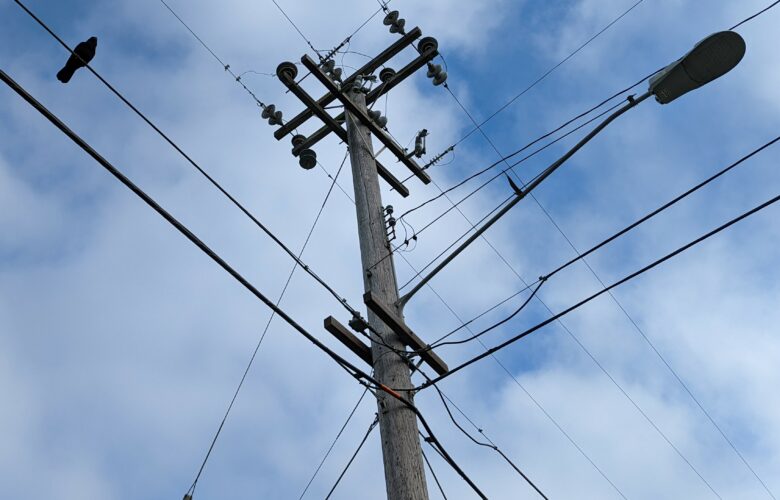 A utility pole and power lines are seen from below. For years, residents of San Francisco’s Treasure Island have faced frequent power outages that complicated daily life.