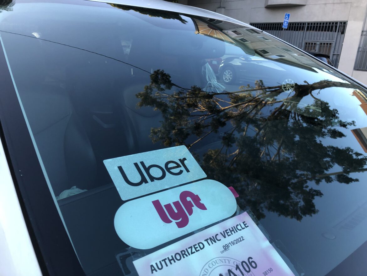 a ride-hailing car displays Uber and Lyft logos
