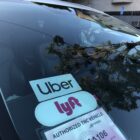 a ride-hailing car displays Uber and Lyft logos