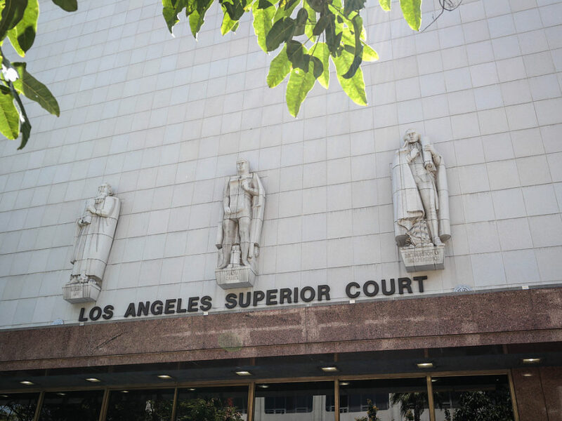 The entrance to Los Angeles Superior Court's Stanley Mosk Courthouse is shown, with three robed stone figures above the doorway.
