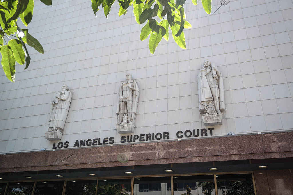 The entrance to Los Angeles Superior Court's Stanley Mosk Courthouse is shown, with three robed stone figures above the doorway.