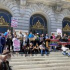 Activists and healthcare providers gather on the steps of San Francisco’s City Hall on March 21 during a die-in rally to demand renewed efforts in the public health fight against HIV.