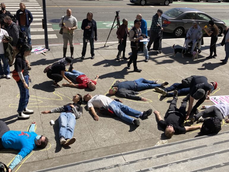 More than 15,800 San Francisco residents live with HIV. Activists stage a die-in at San Francisco’s City Hall on March 21 to demand renewed efforts in the public health fight against the virus.