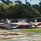 Volunteers spread open a panel of the AIDS Memorial Quilt during an opening ceremony on Saturday, June 11, 2022, at Robin Williams Meadow in Golden Gate Park. This was the largest display of the quilt since it was shown in Washington, D.C., in 2012.