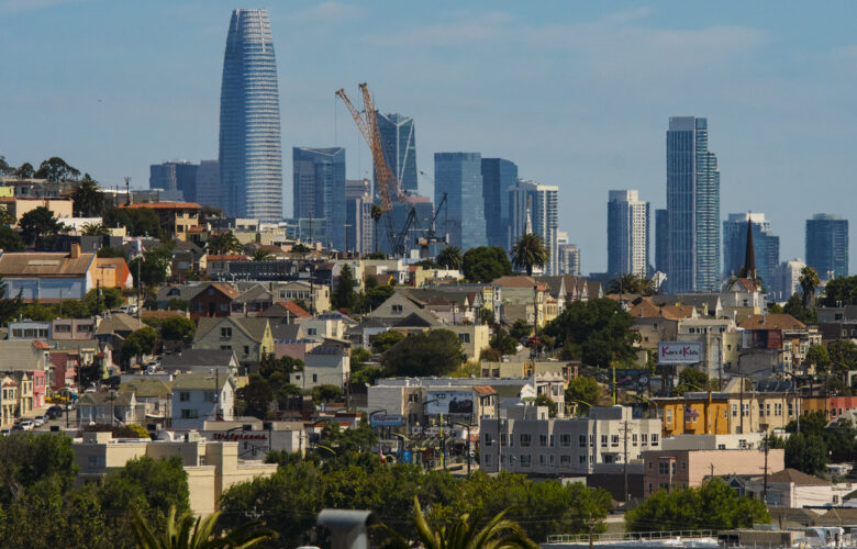 Homes in San Francisco's Bayview-Hunters Point neighborhood are seen against a background of skyscrapers in the city's financial district.