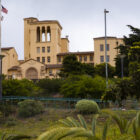 A view from a lower point on the hillside looking across lush green gardens and up toward Laguna Honda Hospital's Spanish Revival-style buildings.