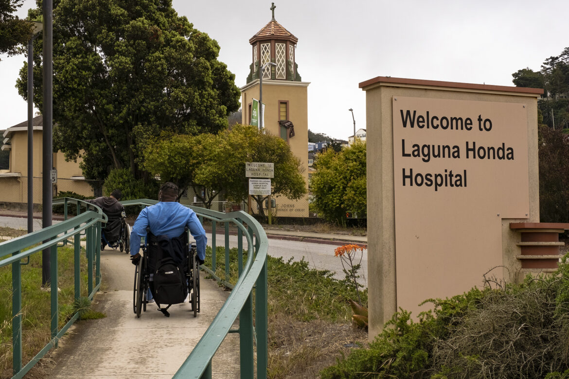 After a smoke break, two patients roll their wheelchairs up a ramp toward the entrance of Laguna Honda Hospital in San Francisco’s Twin Peaks neighborhood.