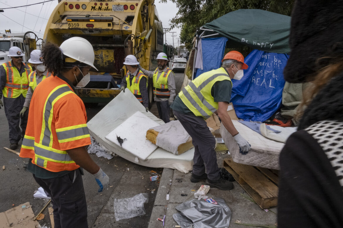 Workers dismantle Jennifer’s bed and toss it into the garbage truck.