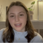 A young woman with shoulder-length brown hair and wearing a pale blue sweater faces forward and appears to be speaking in a screen-grab image from a TikTok video.