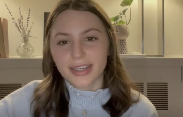 A young woman with shoulder-length brown hair and wearing a pale blue sweater faces forward and appears to be speaking in a screen-grab image from a TikTok video.