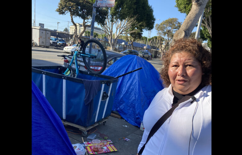Aurelia Ramirez walks by tents and debris along Folsom Street.