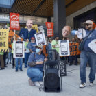 Protesters carry signs that show images of phones mimicking an app with different prices displayed and other signs reading "END UBER'S INEQUALITY MACHINE," "DRIVERS DEMAND TRANSPARENCY" and "DRIVERS DEMAND FAIRNESS."