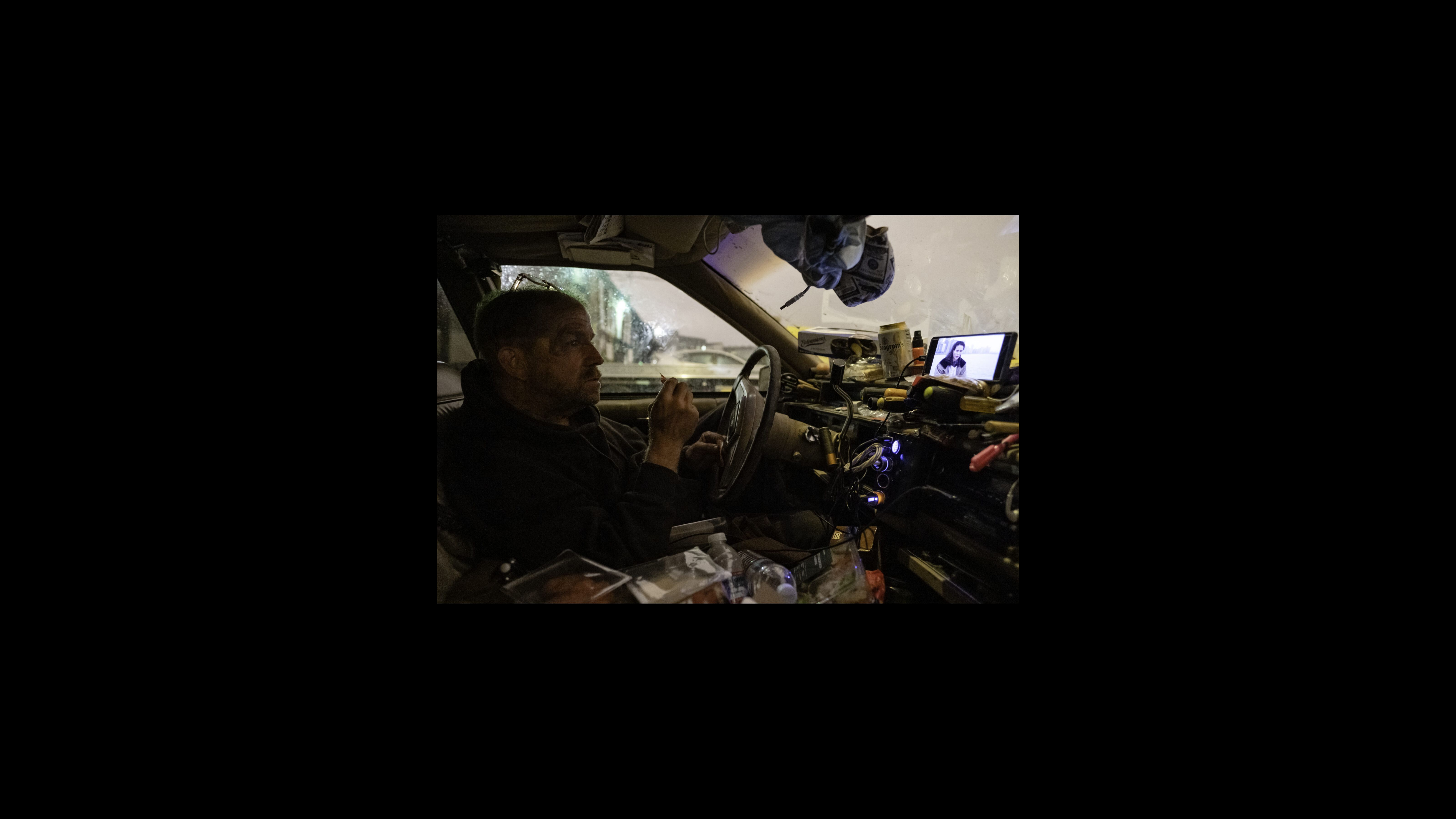 Nelson sits back on his driver seat inside his Cadillac, eating snacks while he watches one of his favorite ‘90’s movies — “Grosse Pointe Blank.” He enjoys the small pleasures of life like good music, watching movies or video clips on YouTube, and eating snacks like other people sheltering in place. His favorite comfort foods are chocolate milk and doughnuts. Nelson sits back on his driver seat inside his Cadillac, eating snacks while he watches one of his favorite ‘90’s movies — “Grosse Pointe Blank.” He enjoys the small pleasures of life like good music, watching movies or video clips on YouTube, and eating snacks like other people sheltering in place. His favorite comfort foods are chocolate milk and doughnuts.