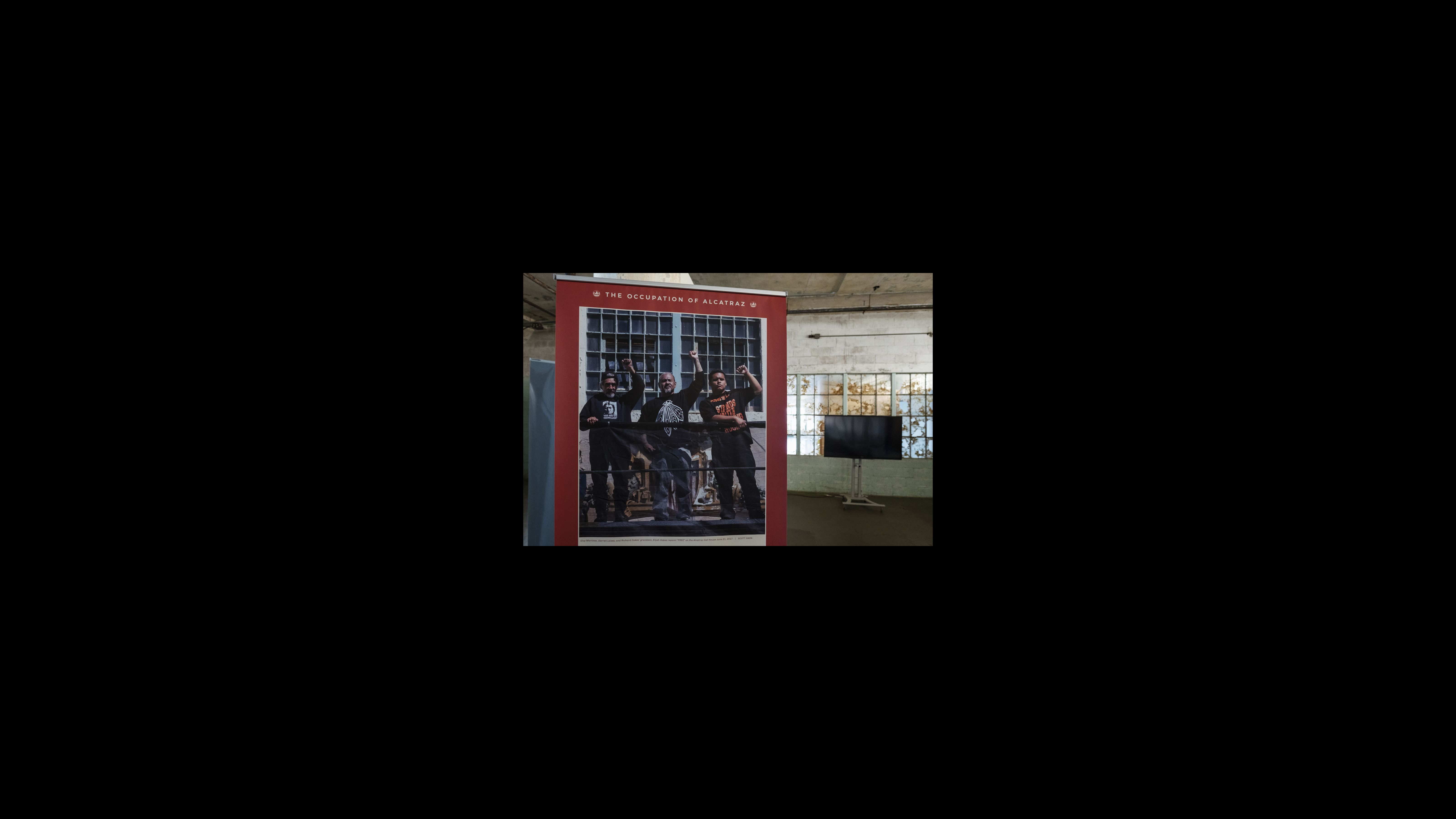 Photographer Scott Hahn took a portrait of former occupiers Eloy Martinez and Darren Laiwa with the grandson of Richard Oakes, who was a leader in the occupation, raising their fists after they repainted the word “FREE” on the shield at Eagle Plaza on June 21, 2017.
During the occupation, the Indians of All Tribes wrote a proposal outlining their vision for the island, which included a Native Museum “consisting of Native cultural exhibits. Also there will be a Native Archives and library collection with original documentations of how the “white man” committed genocide to our people and to other peoples in the past and present.” A portrait of former occupiers Eloy Martinez and Darren Laiwa with the grandson of Richard Oakes, who was a leader in the occupation, raising their fists after they repainted the word “FREE” on the shield at Eagle Plaza.