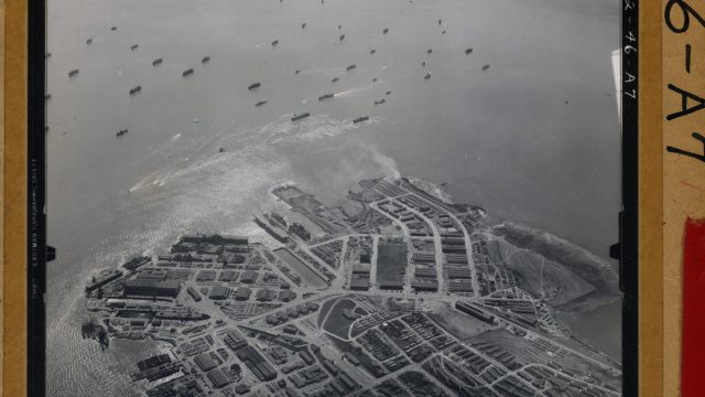 The military’s choice to build its leading radiation lab at the San Francisco Naval Shipyard in Hunters Point, seen from the air in a print hand-labeled “1946,” came after ships from Pacific atom bomb tests returned to U.S. shores “hot,” giving scientists an opportunity to study decontamination techniques. Source: National Archives and Records Administration. A black-and-white aerial photo of the Hunters Point shipyard in San Francisco Bay