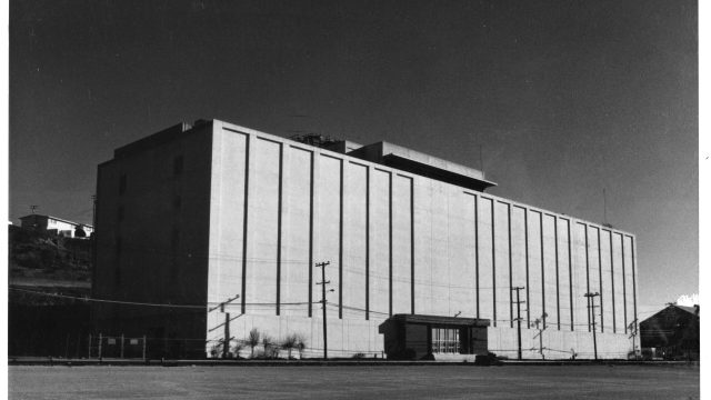 The nearly windowless headquarters building of the Naval Radiological Defense Laboratory, which cost $8 million to build in 1955, was a major hub for science experiments using radioactive materials. Source: National Archives and Records Administration. A six-story white, nearly windowless building in a black-and-white photo