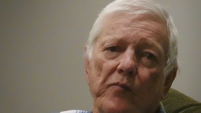 Eldridge Jones served in the Army’s 50th Chemical Platoon, participating in exercises that exposed him to radiation. He says his health issues may be related to research organized by the Navy’s San Francisco laboratory. close-up of a white-haired man wearing a plaid shirt looking pensive and facing the camera