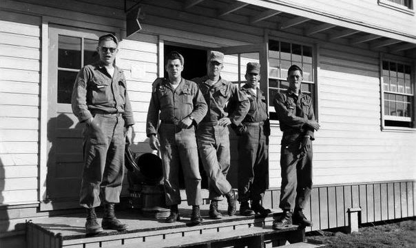Eldridge Jones, center, and fellow soldiers received radiation exposure in Nevada nuclear weapons tests, and later in Bay Area land decontamination experiments. Source: 50th Chemical Platoon Blog. five men in uniform stand casually on a wooden porch in a black-and-white photo