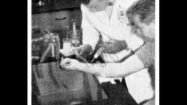 Scientists placed radioactive samples on subjects’ forearms, where beta radiation could cause burns and could not be easily washed off. Source <a href="https://www.documentcloud.org/documents/21175929-decontamination-of-synthetic-fallout-from-human-skin-feb-1958-2?responsive=1&title=1">📄</a>: “Stoneman I — Decontamination of Synthetic Radioactive Fallout From Intact Human Skin,” American Industrial Hygiene Association Journal. A black-and-white photo of a scientist in a white lab coat uses a syringe to place a liquid on the arm of a young man in a laboratory